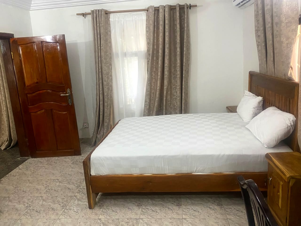 Bedroom with wooden door and curtains