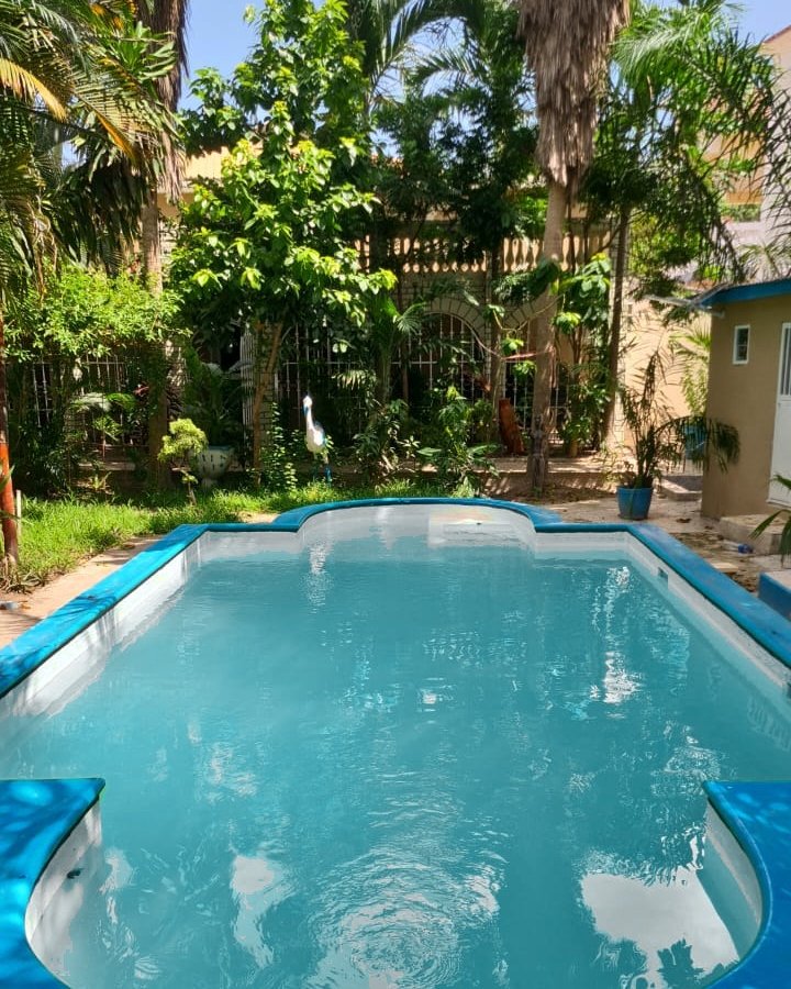 The pool in front of the Main House with its arched windows, under a blue sky