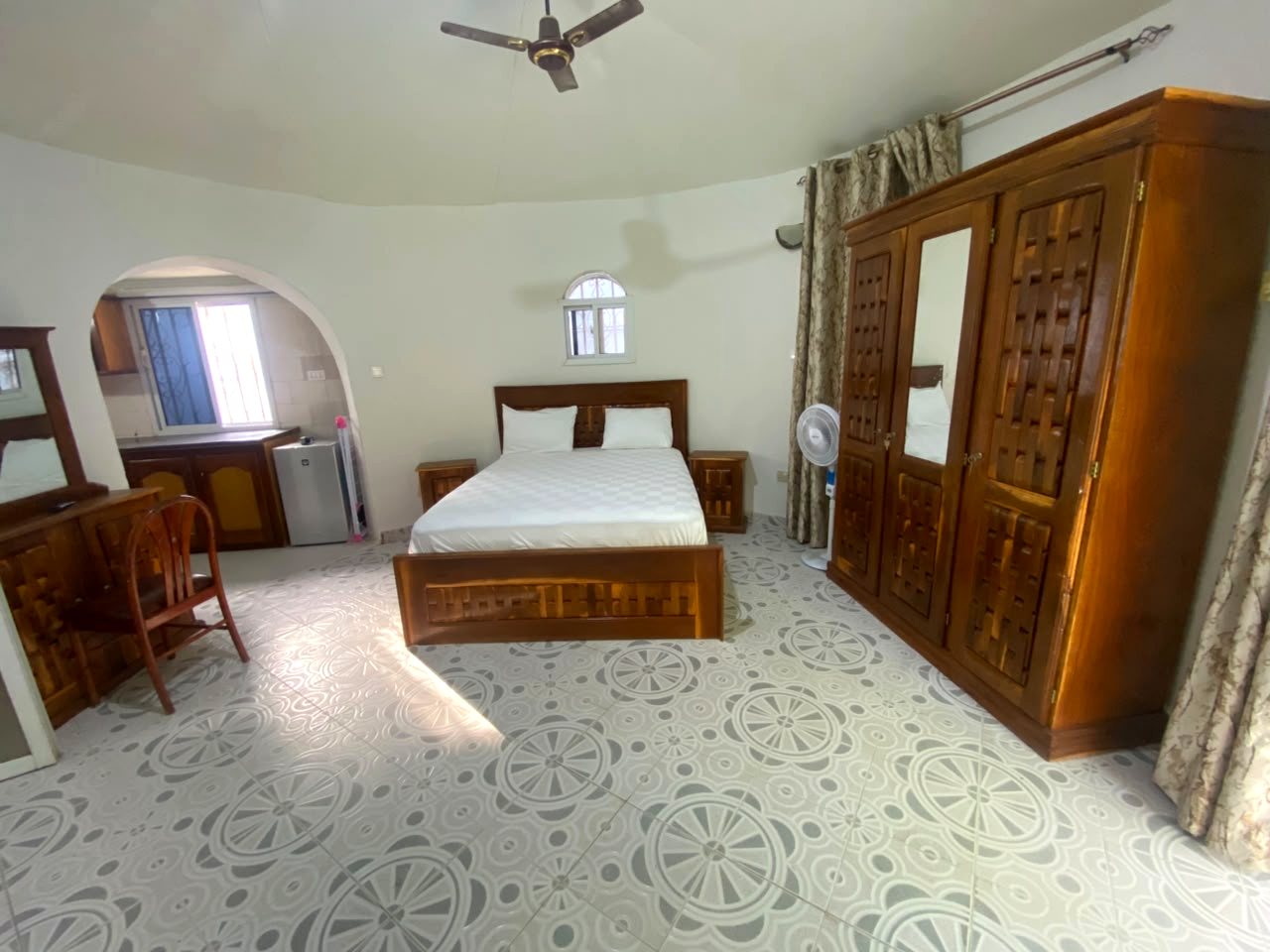 Bedroom with wardrobe and arched doorway to the kitchenette